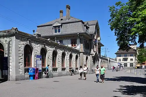 Forecourt and three-story railway station building with wings either side